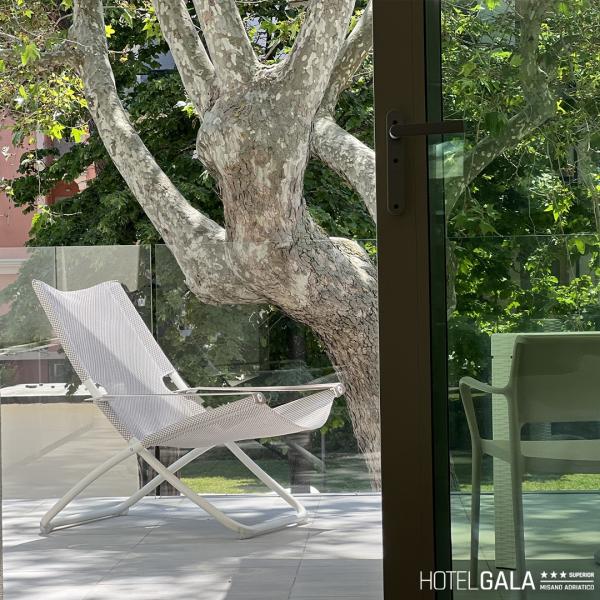 White chair on terrace with tree, Hotel Gala.