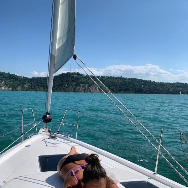 Person relaxing on a sailboat at sea.