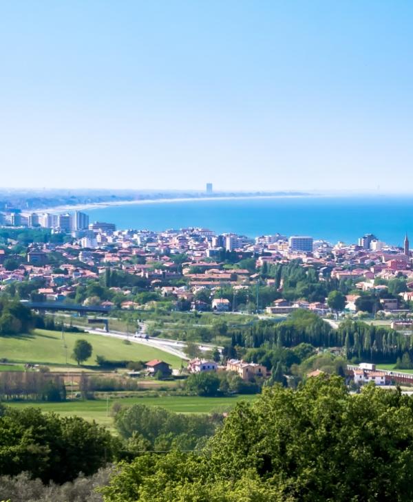 Vista panoramica di una città costiera con edifici e mare sullo sfondo.