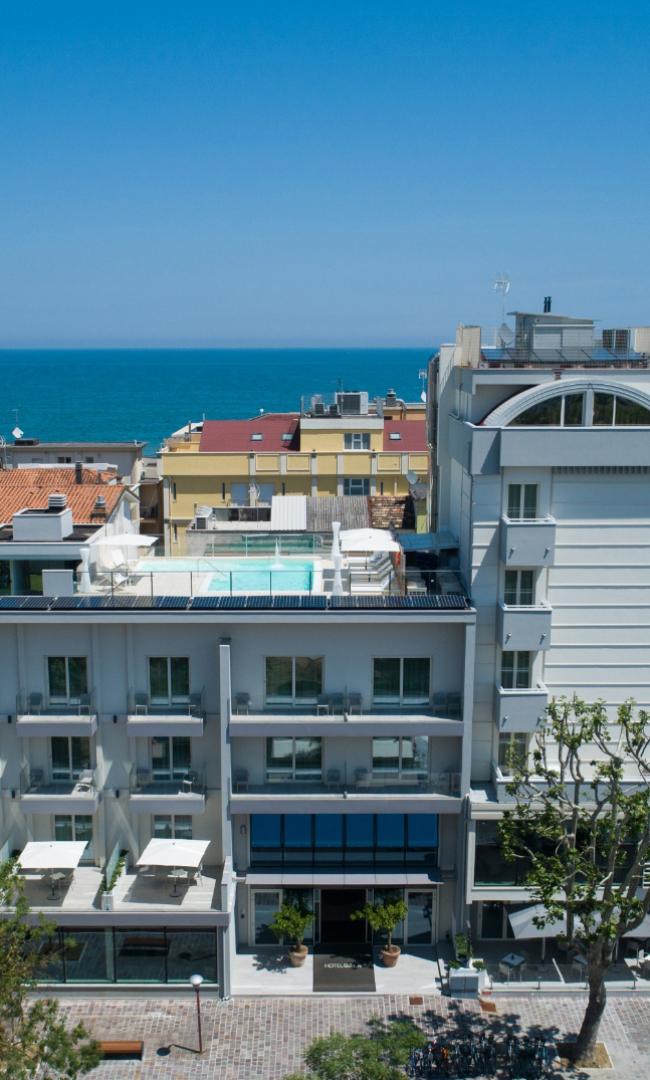 Hotel moderno con piscina sul tetto e vista sul mare.