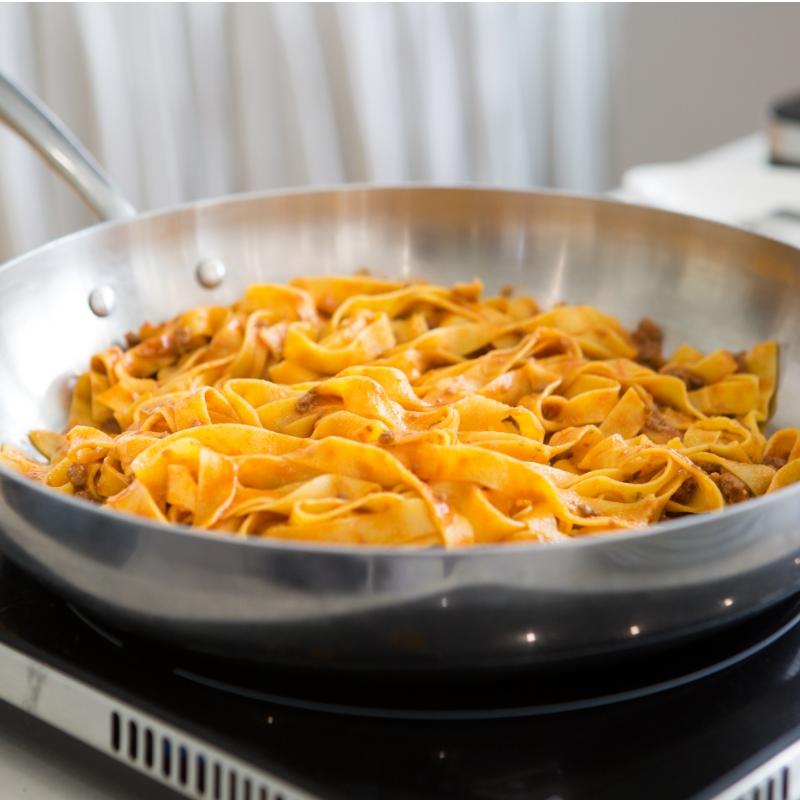 Tagliatelle al ragù in padella, pronte per essere servite.